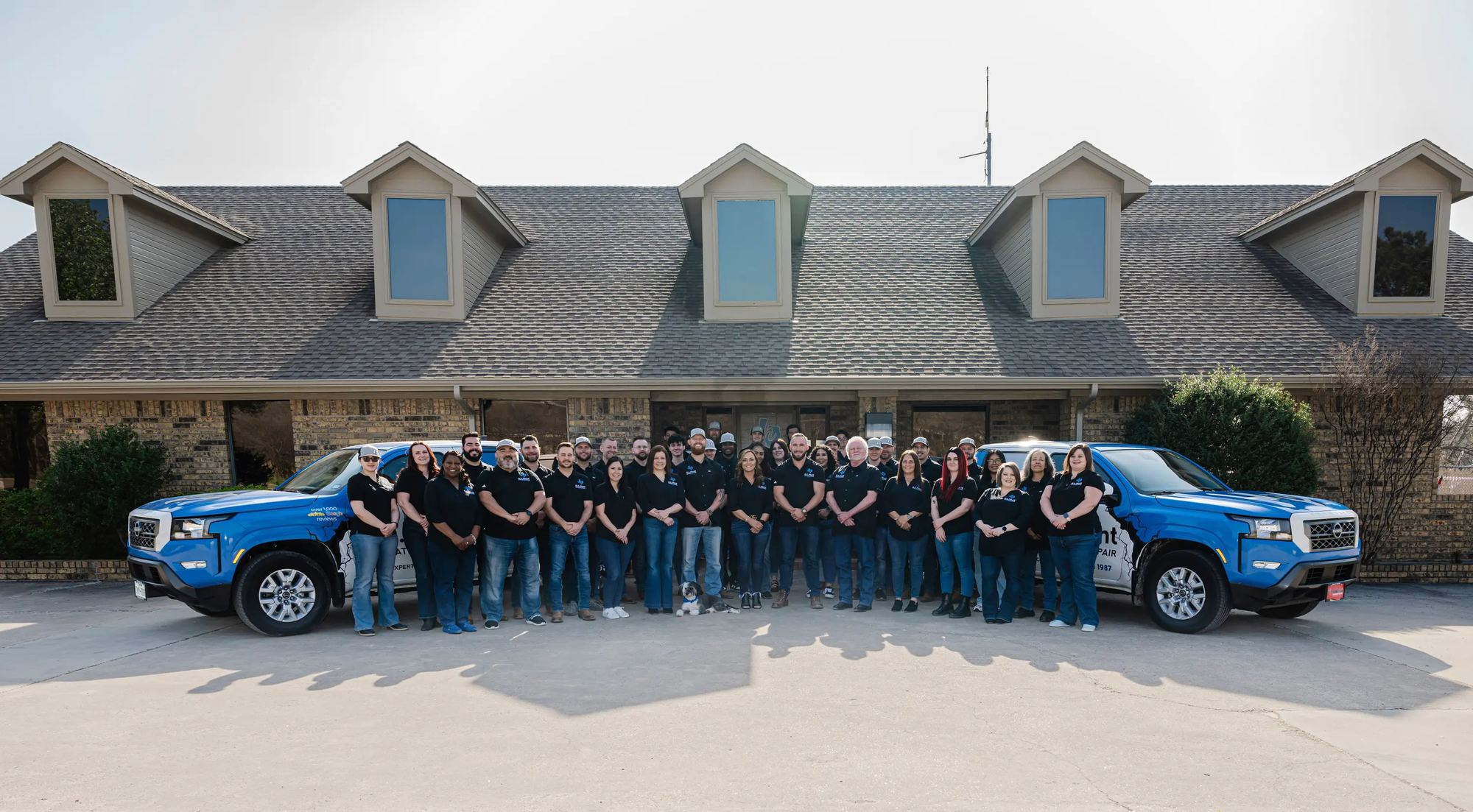 The G.L. Hunt team with company trucks